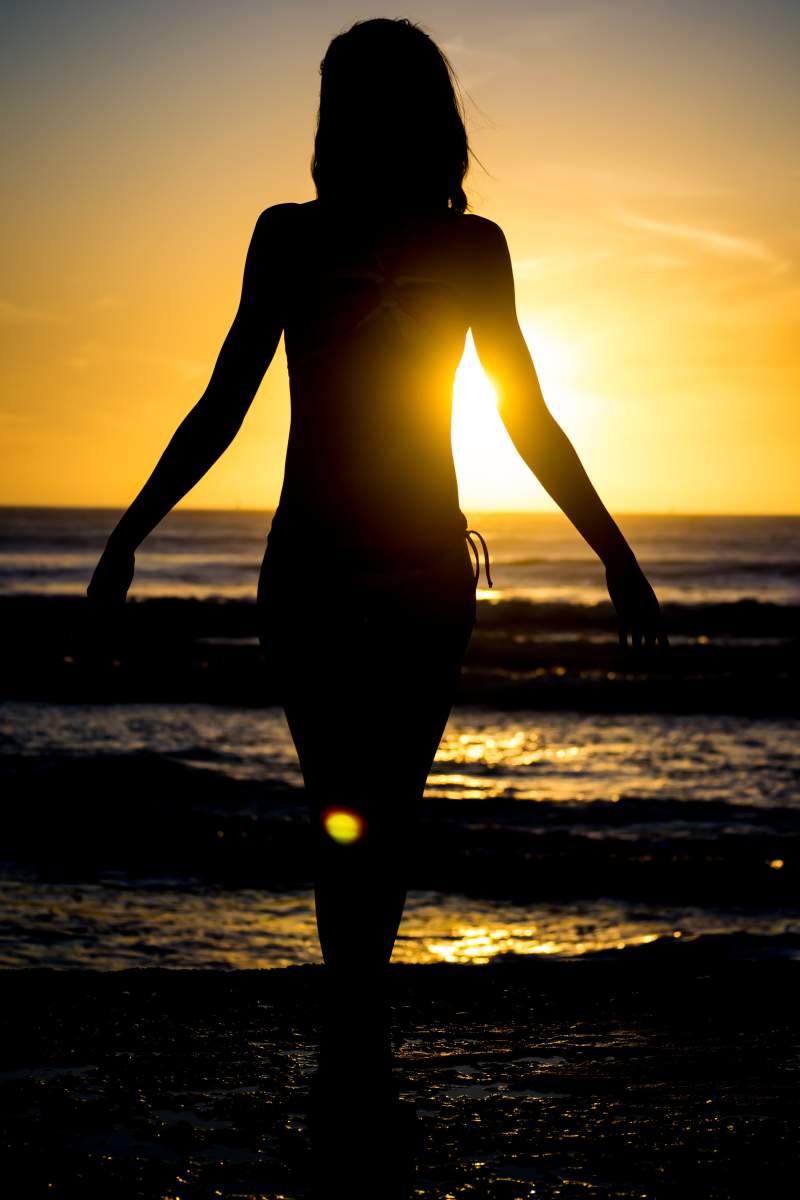Silhouette floue face à la mer au coucher de soleil, illustrant l’ambiance libre et sensuelle du village naturiste du Cap d’Agde.